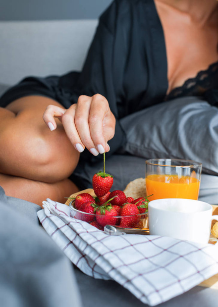 Breakfast in bed. Young beautiful brunette woman - Valokuva, kuva