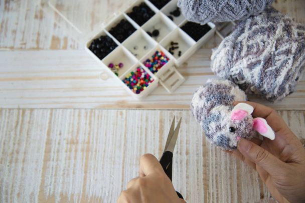 Woman making lovely bunny doll from yarn  - Easter holiday celebration concept - Foto, imagen