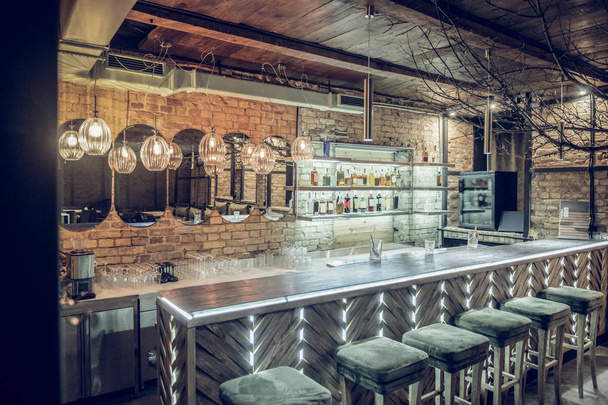 Photo of loft bar brick interior being decorated with lighting - Foto, imagen