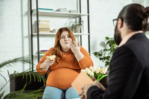 Professional therapist interviewing his plump young client - 写真・画像