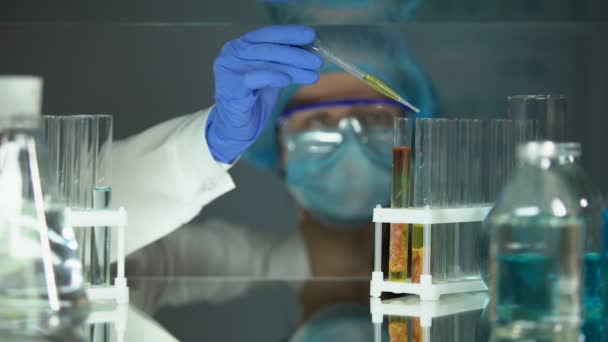 Laboratorní asistent kapající chemickou kapalinu v trubce se vzorkem masa, jakost potravin - Záběry, video