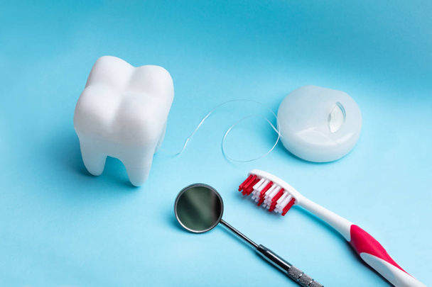 Gros plan de la dent artificielle blanche et de l'équipement dentaire sur fond bleu
 - Photo, image
