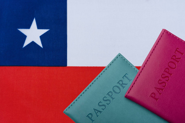 На фоне флага Чили находятся паспорта
. - Фото, изображение