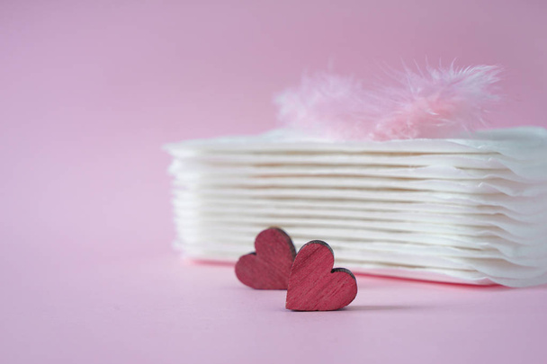 Zásobník menstruační vložky s červené srdce a peří na barvu pozadí - Fotografie, Obrázek