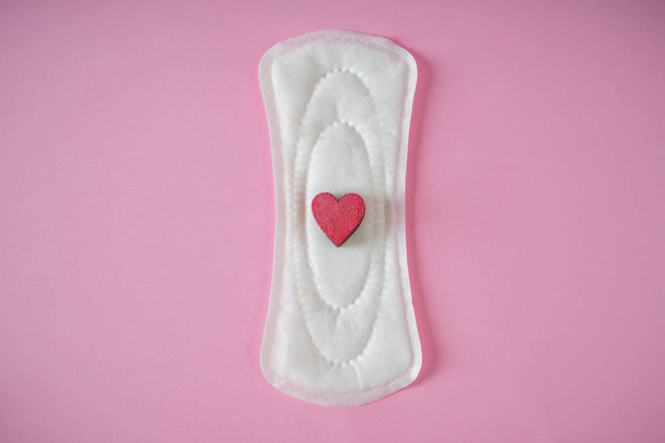 Menstrual pad with red heart on color background - Foto, afbeelding