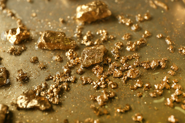 Goudklompjes op metalen oppervlak, close-up - Foto, afbeelding