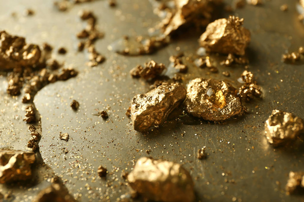 Золотые самородки на металлической поверхности, крупный план
 - Фото, изображение