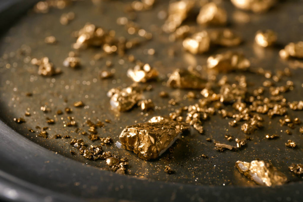 Goudklompjes op metalen plaat, close-up - Foto, afbeelding