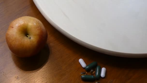 apple versus drugs on a table - Materiał filmowy, wideo