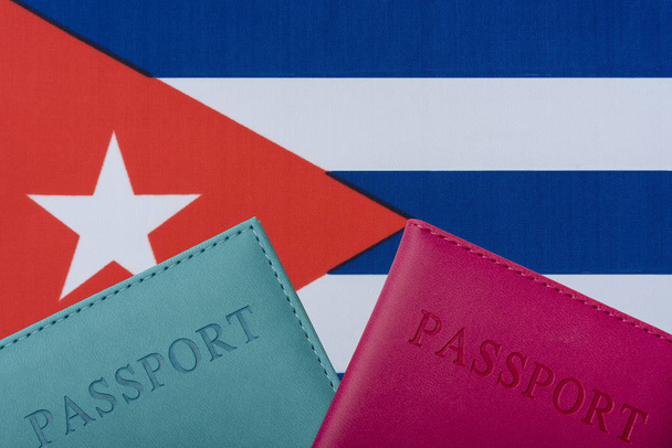 На фоне флага Кубы лежат паспорта
. - Фото, изображение