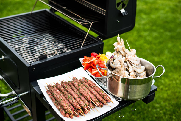 Appetizing shrimps and meat with vegetables cooking on grill - Photo, Image