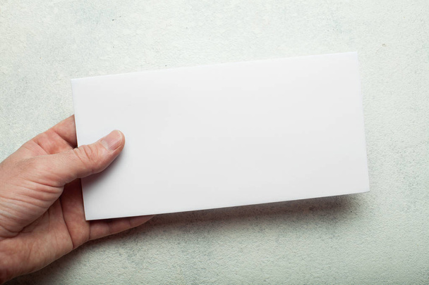 Empty white postcard blank in hand on white background. Leaflet, - Fotoğraf, Görsel