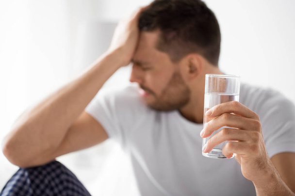 close up of sick man with glass of water - Photo, Image