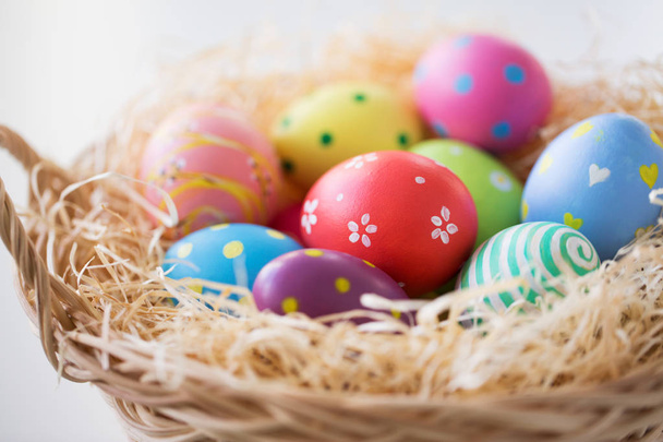 close up of colored easter eggs in basket - Fotó, kép
