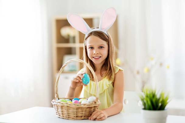 happy girl with colored easter eggs at home - Фото, изображение