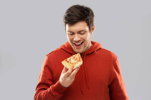 happy young man eating pizza - Zdjęcie, obraz