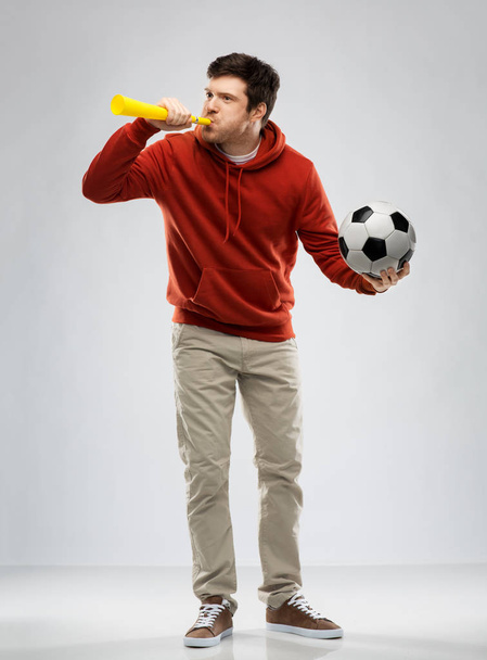football fan with soccer ball blowing horn - Фото, изображение