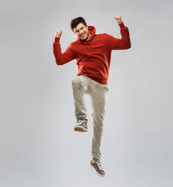 man in hoodie jumping and celebrating success - Fotoğraf, Görsel