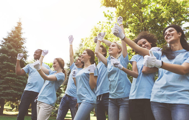 Grupa wolontariuszy zadowolony świętować sukces się w parku - Zdjęcie, obraz
