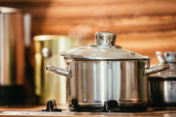 Steaming metal pot in the kitchen, wood - Photo, Image