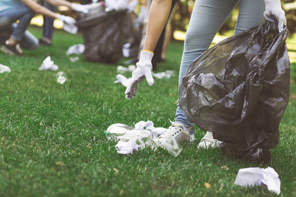 Młodzi ochotnicy zbieranie śmieci w parku suumer - Zdjęcie, obraz