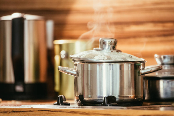 Steaming metal pot in the kitchen, wood - Fotó, kép
