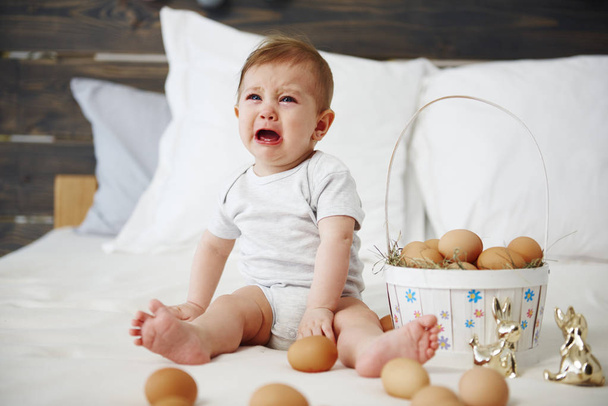 Plačící dítě slaví velikonoční ráno v posteli  - Fotografie, Obrázek