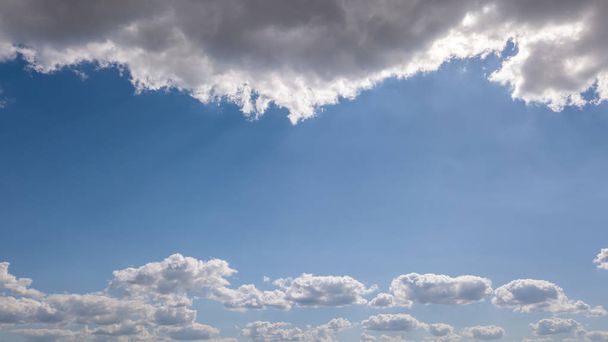 Aerial view of sun lights through white clouds on a background of blue sky. Natural cloudy frame. Place for text. - Φωτογραφία, εικόνα