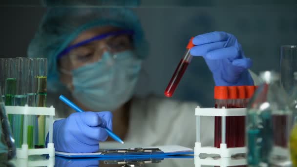 Tudós ellenőrző cső vérelemzéssel és jegyzetkészítéssel, járványkitörés - Felvétel, videó