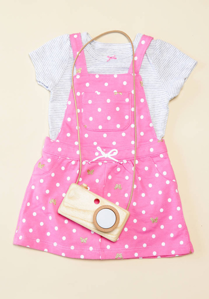 Bebek kız bahar kıyafeti, pembe elbise ve ahşap kamera oyuncak, üst görünüm - Fotoğraf, Görsel