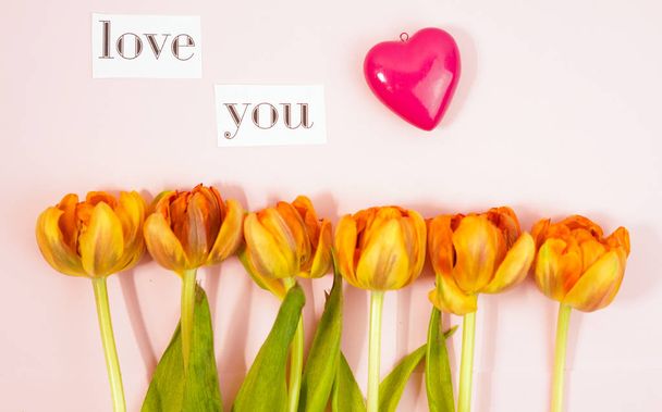 Row of tulips on coloful background with space for message. Mothers Day background. Top view - Photo, Image