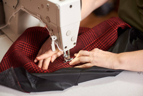 gros plan des mains féminines couture tissu blanc sur la machine de fabrication professionnelle sur le lieu de travail
 - Photo, image