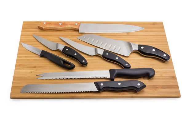 Кухонные ножи различного назначения на доске для резки бамбука
 - Фото, изображение