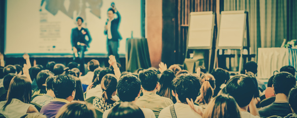 Πανό ομιλητές στη σκηνή με οπίσθια όψη του κοινού στην διάσκεψη αίθουσα ή σεμινάριο σύσκεψη, εργασία και εκπαίδευση έννοια - Φωτογραφία, εικόνα