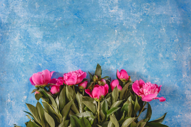 bouquet of pink-purple peonies in a vase on a blue marble-concre - Φωτογραφία, εικόνα