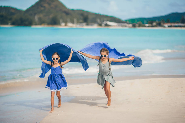 Les petites filles s'amusent avec une serviette de plage pendant les vacances tropicales
 - Photo, image