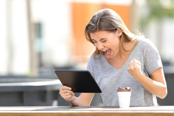 Ενθουσιασμένος κορίτσι εξεύρεση online περιεχόμενο σε ένα tablet σε ένα πάρκο - Φωτογραφία, εικόνα