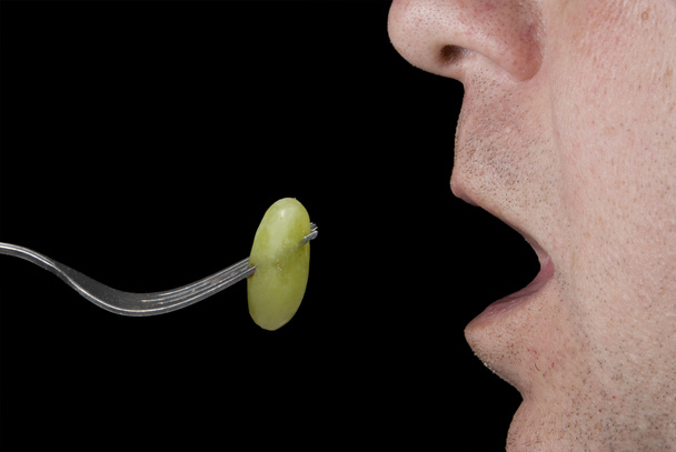 Hombre comiendo una uva
 - Foto, imagen