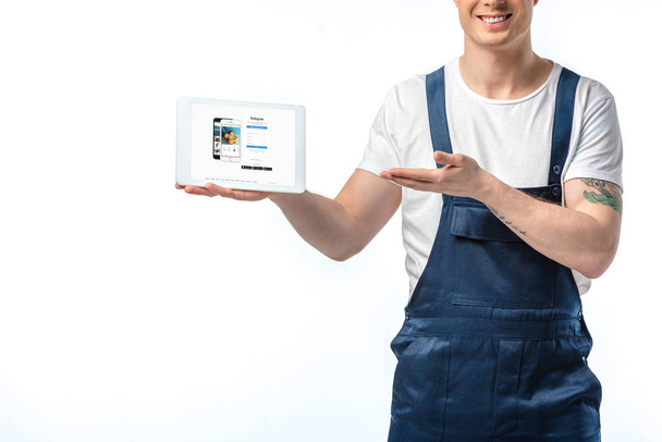 cropped view of smiling mover gesturing and presenting digital tablet with instagram app on screen isolated on white - Fotoğraf, Görsel
