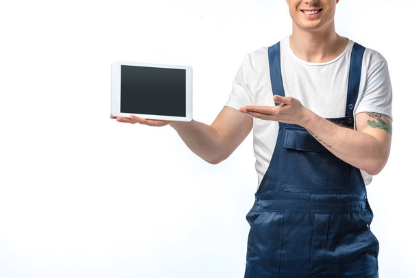 vue recadrée du déménageur souriant gesticulant à la main et présentant une tablette numérique avec écran blanc isolé sur blanc
 - Photo, image