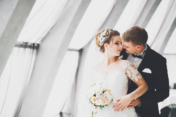 Perfect couple bride, groom posing and kissing in their wedding day - Fotó, kép