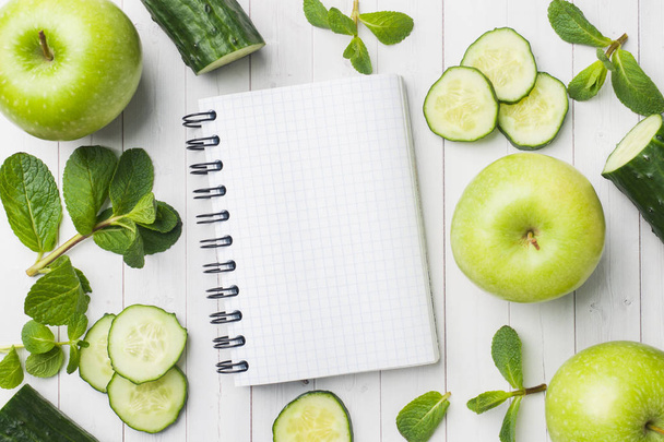 grüne Gurken Minze Apfel auf dem Tisch. das Konzept der Ernährung und des Vegetarismus. Kopierraum. Notizblock für Text - Foto, Bild