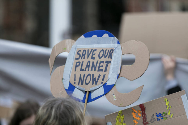 People with banners protest as part of a climate change march - Foto, Imagen