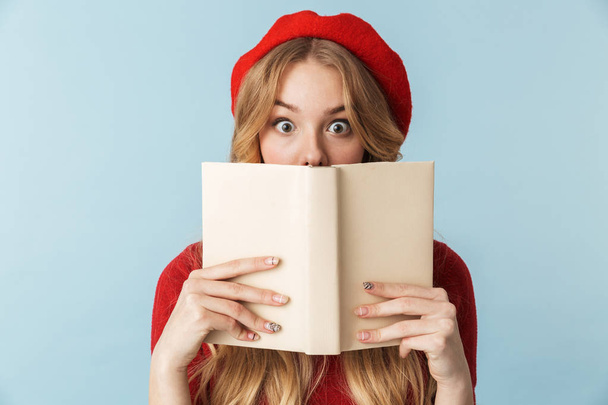 Akıllı sarışın kadın 20'li yaşlarda giyen kırmızı bere okuma kitabı görüntüsünü - Fotoğraf, Görsel