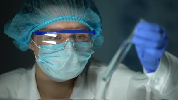 Researcher analyzing reaction in tube with blue transparent liquid, detergents - Felvétel, videó