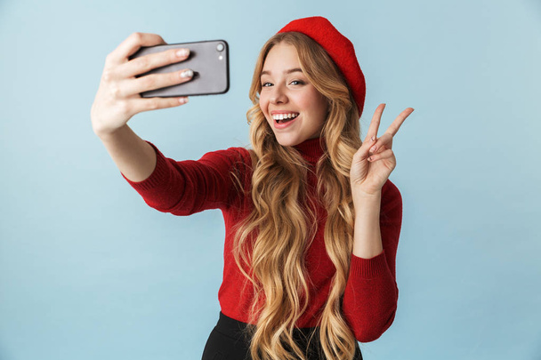 Foto da menina loira 20s vestindo boina vermelha levando selfie no mobi
 - Foto, Imagem