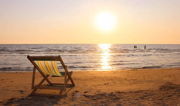Пляжный шезлонг на пляже в час заката
 - Фото, изображение