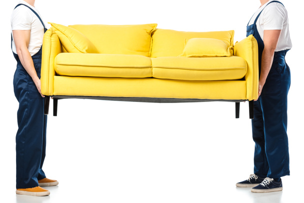 cropped view of two movers transporting yellow sofa on white - Photo, Image