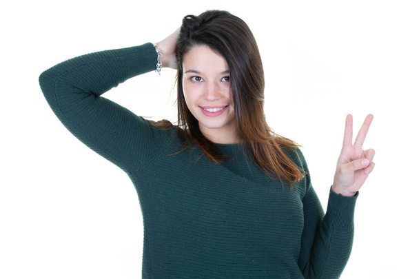 Щаслива молода жінка святкує знак перемоги з пальцями на білому тлі
 - Фото, зображення