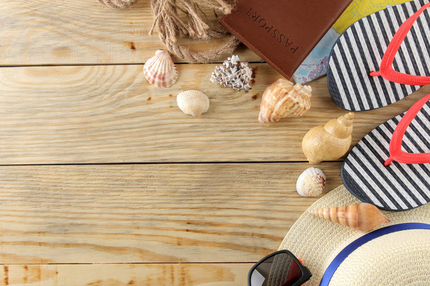 Concepto de viaje Sombrero, gafas, chanclas y conchas sobre una mesa de madera natural. Relajación. vacaciones. Vista superior. espacio libre
 - Foto, Imagen